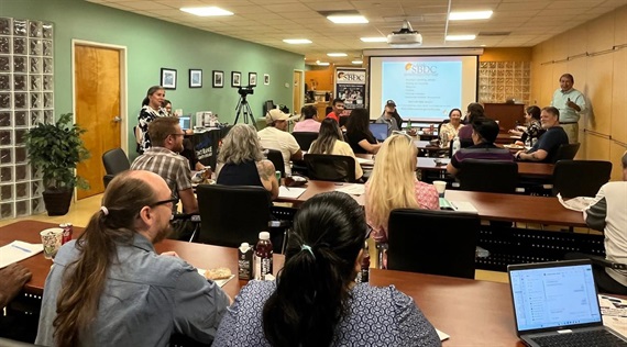 Photo of people in front of a rpesentation from SBDC